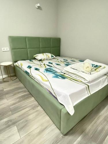 1 cama grande con cabecero verde en un dormitorio en Апартаменты аэропорт 1, en Turksib