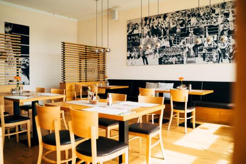 comedor con mesas y sillas de madera en business & conference Sporthotel Großwallstadt, en Großwallstadt
