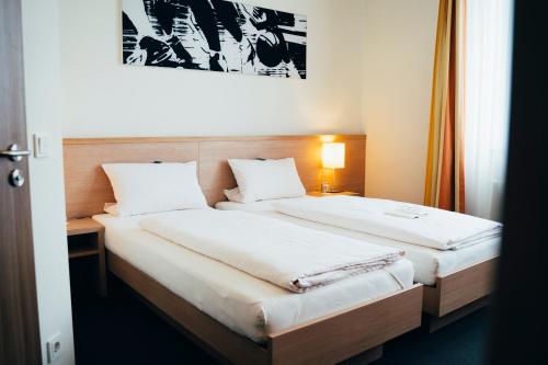 two beds in a hotel room with at business & conference Sporthotel Großwallstadt in Großwallstadt