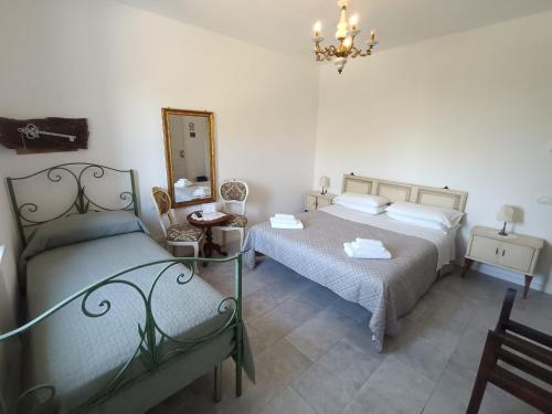1 dormitorio con 2 camas, espejo y silla en b&b RetrO'Conero, en Castelfidardo