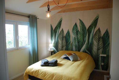 1 dormitorio con un gran mural de hojas en la pared en Gîte'appart "des cîmes et jardin", en Illkirch-Graffenstaden