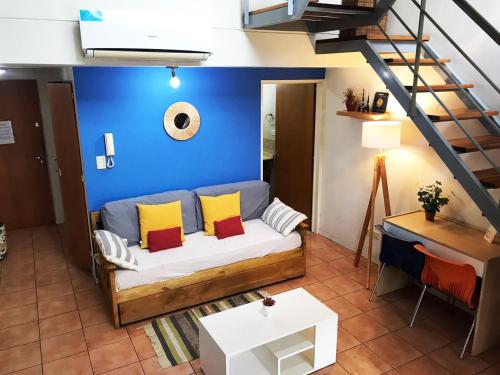 sala de estar con sofá y pared azul en Duplex dos ambientes con terraza propia y parilla en Buenos Aires