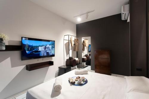 Cette chambre dispose d'une télévision et d'un lit avec une assiette de nourriture. dans l'établissement Bocà Home, à Salerne