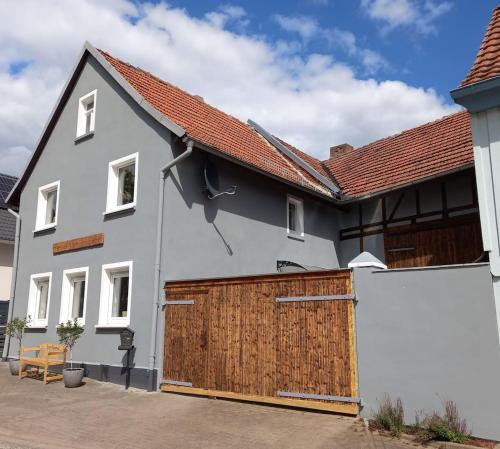 ein weißes Haus mit einer hölzernen Garagentür in der Unterkunft Pension - Kleinschmidt in Urbach
