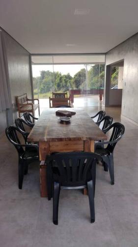a dining room table with chairs and a wooden table at Rancho Pôr do Sol in Piumhi