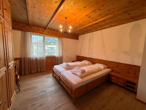 een slaapkamer met een bed en een houten plafond bij Luxury Apartment Davos in Davos