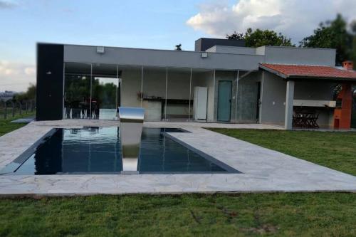 una casa con piscina frente a ella en Rancho Pôr do Sol en Piuí