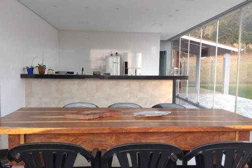 a large wooden table in a kitchen with chairs at Rancho Pôr do Sol in Piumhi