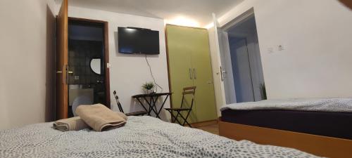 a bedroom with a bed and a television on the wall at Budget Friendly in Požega