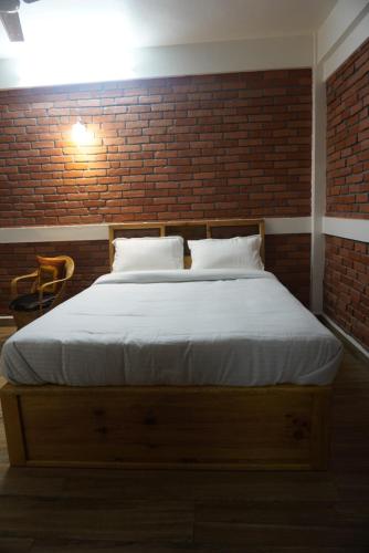 a bed in a room with a brick wall at Dorsen Homestay in Shillong