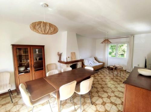 ein Wohnzimmer mit einem Holztisch und weißen Stühlen in der Unterkunft Entre terre et mer 