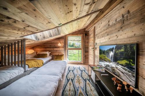 Cette chambre comprend 2 lits et une grande télévision. dans l'établissement Apartment Tourmalet Carrôz d'Arâches - BY EMERALD STAY, aux Carroz d'Arâches