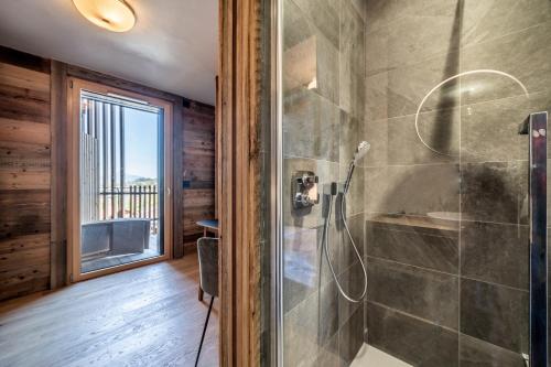 une salle de bain avec une douche avec une porte vitrée dans l'établissement Apartment Tourmalet Carrôz d'Arâches - BY EMERALD STAY, aux Carroz d'Arâches
