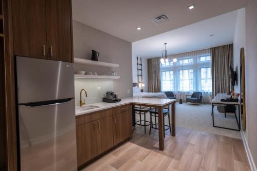 a kitchen with a refrigerator and a table in a room at Hotel Covington Cincinnati Riverfront in Covington