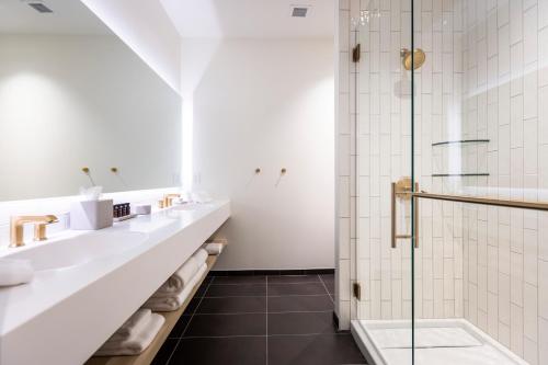 a bathroom with two sinks and a shower at Hotel Covington Cincinnati Riverfront in Covington