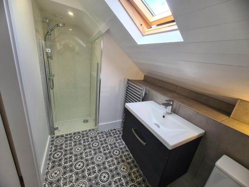 un baño con lavabo y ducha en Saltwater, en St Ives