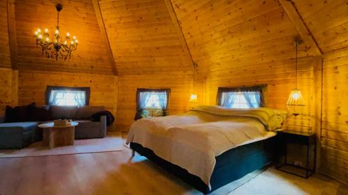 ein Schlafzimmer mit einem Bett in einem Holzzimmer in der Unterkunft Koselig dyregård i Tromsø in Tromsø