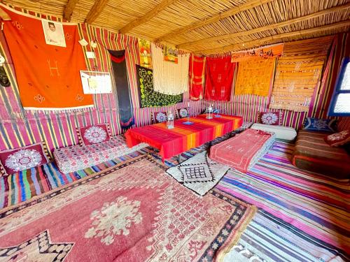 a room with a table and chairs in a room at Mhamid Sahara Camp Activities - Le Chant du Sable in Mhamid