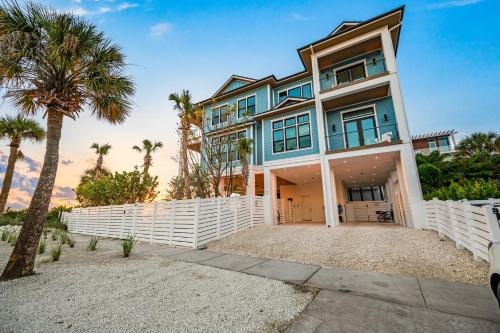 una casa con una valla blanca y palmeras en Sunset Blue, en Siesta Key