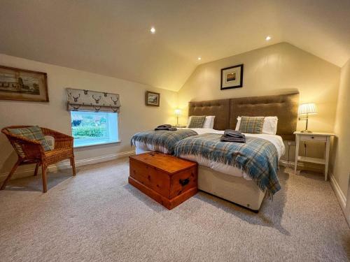 a bedroom with a bed and a chair and a window at Well Furnished Holiday Cottage In The Heart Of Docking, Norfolk Ref 99009ht in Docking
