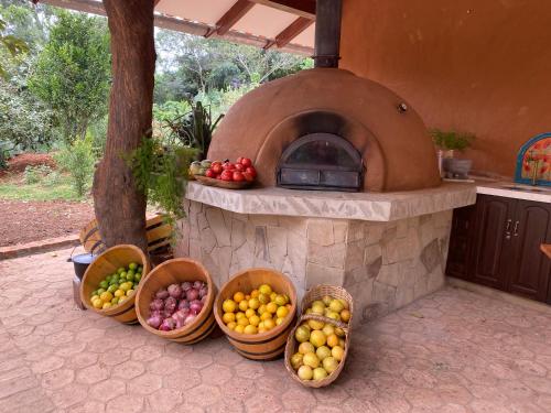 a stone oven with baskets of fruit on a patio at Finca La Vispera in Samaipata