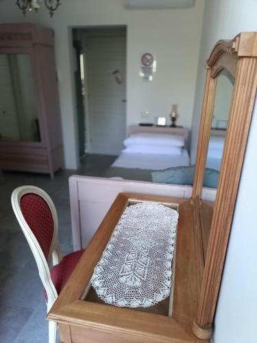 a room with a table with a mirror and a bed at b&b RetrO'Conero in Castelfidardo