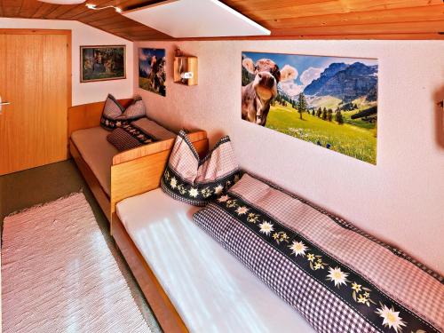 una habitación con 2 camas y una foto de una vaca en la pared en Walserhaus, en Brand