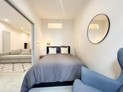 1 dormitorio con cama, espejo y sofá en Suite Onyx, en Lyon
