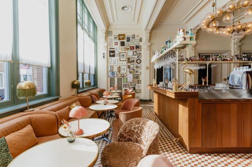 a restaurant with tables and chairs and a bar at Hotel Mercier in Amsterdam