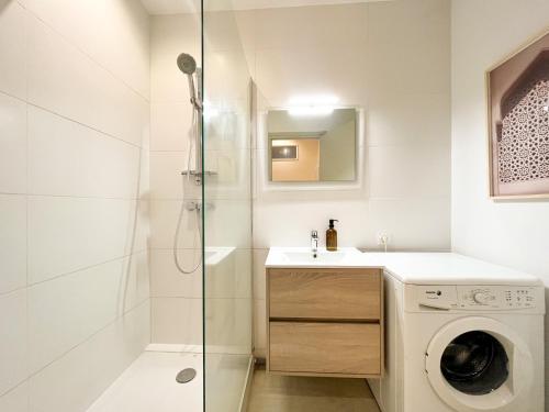 a bathroom with a washing machine and a sink at Suite Onyx in Lyon