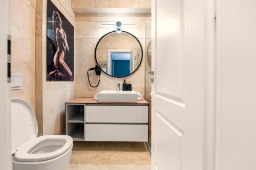 bagno con lavandino, servizi igienici e specchio di Pitesti Residence a Piteşti
