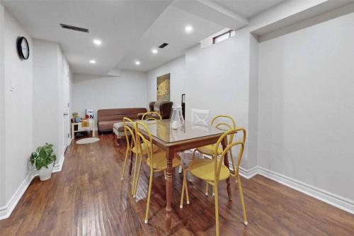 a dining room with a table and yellow chairs at Executive Apartment - 2 Bedrooms in Barrie