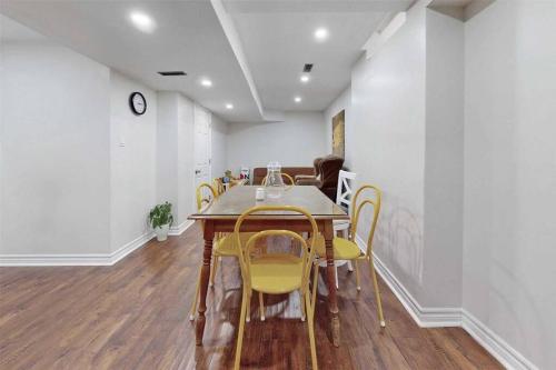 a dining room with a table and yellow chairs at Executive Apartment - 2 Bedrooms in Barrie