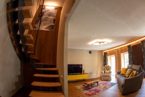 a staircase in a living room with a couch and a television at La Noix - Alloggi ad uso turistico - VDA - ARVIER - n 0041 e n 0042 in Arvier