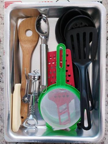 a sink filled with cooking utensils and a spatula at Ap Vista Mar em Caraguatatuba in Caraguatatuba