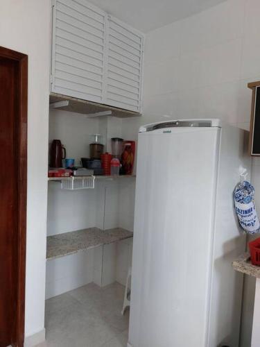 a kitchen with a white refrigerator in a room at Ap Vista Mar em Caraguatatuba in Caraguatatuba