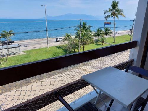 a balcony with a table and a view of the ocean at Ap Vista Mar em Caraguatatuba in Caraguatatuba