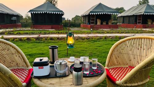 una mesa con comida y bebidas encima de las sillas en Pritampalace resort, en Khilchīpur