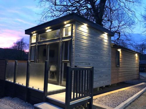 Une petite maison en bois éclairée dans l'établissement V28 - The Lookout with Hot Tub, à Bangor