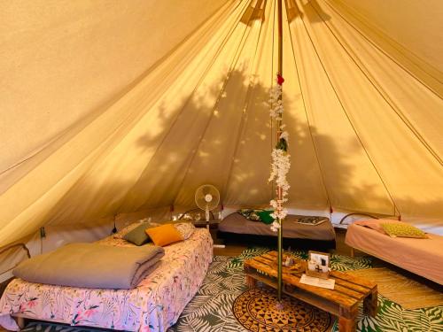 um quarto com 2 camas numa tenda em Tente inuit cocooning em Urtaca