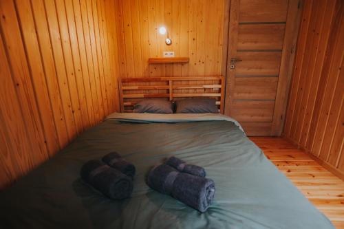 a bedroom with a bed in a wooden cabin at Brīvdienu māja Jaunzvīņas in Upesgrīva