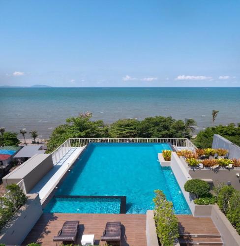 a swimming pool with the ocean in the background at The Blu X Family grand Suite in Ban Bang Saen (1)