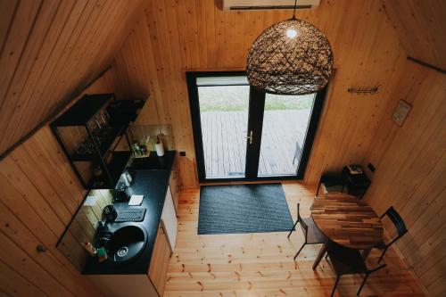 een kamer met een keuken, een tafel en een raam bij Brīvdienu māja Jaunzvīņas in Upesgrīva