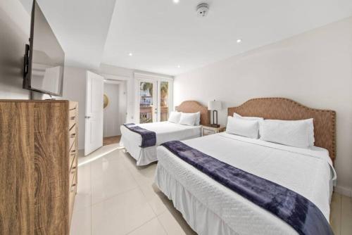 a bedroom with two beds and a flat screen tv at Amazing BahiaMar beachfront 2 steps from amenities in South Padre Island