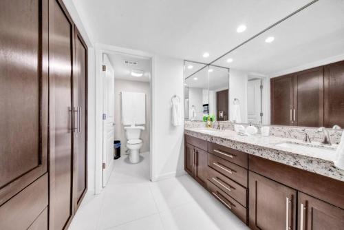 a bathroom with two sinks and a toilet and a mirror at Amazing 7th floor beachfront condo wonderful views in South Padre Island