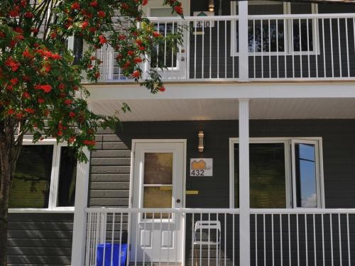 a house with a white railing and a balcony at Résidence Touristique Chicoutimi in Saguenay