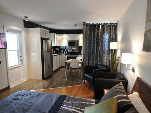 a living room with a bed and a kitchen at Résidence Touristique Chicoutimi in Saguenay