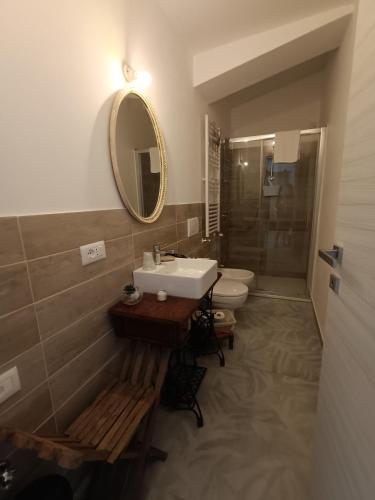 a bathroom with a sink and a toilet and a mirror at b&b RetrO'Conero in Castelfidardo