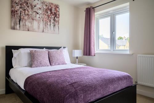 ein Schlafzimmer mit einem Bett mit einer lila Decke und einem Fenster in der Unterkunft Wykebeck Mount by Our Home Short Stays in Killingbeck