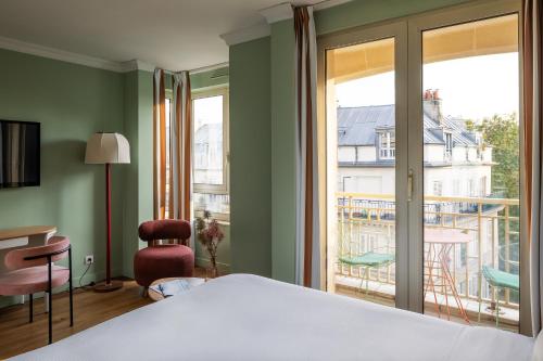 a bedroom with a bed and a view of a balcony at Royal Garden Champs-Élysées in Paris